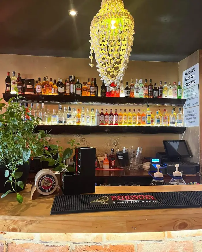 Bar z kryształowym żyrandolem i półkami pełnymi butelek